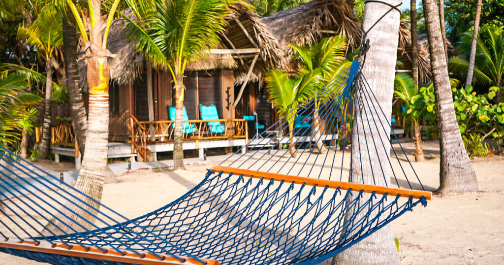 Inviting-hammock-to-unwind-on-beach-vacation-on-a-tropical-beach-in-front-of-a-private-beach-cabana