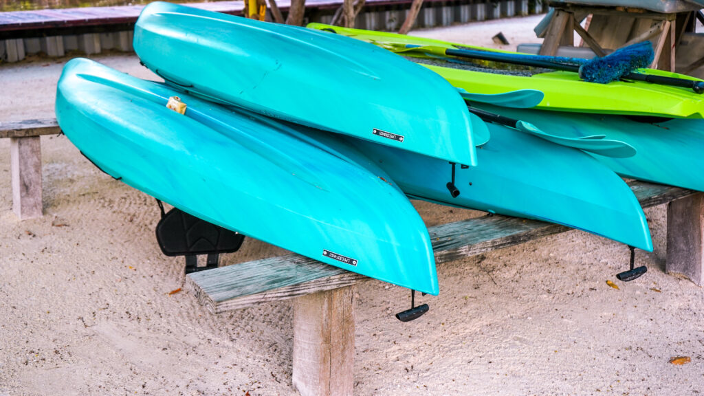 turquoise-kayaks-and-green-paddle-boards-stacked-up
