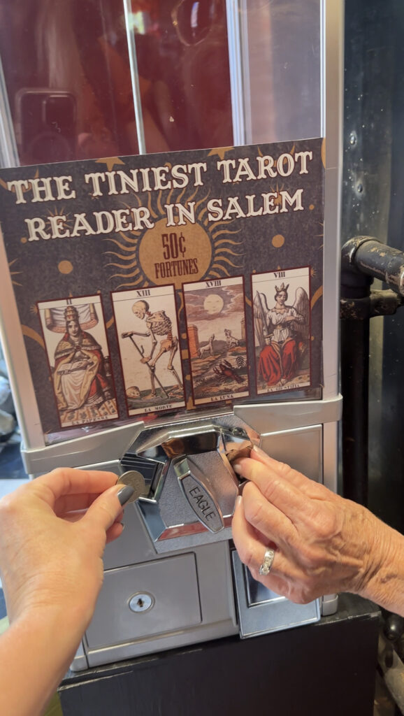 two-hands-reaching-to-salem-tarot-card-vending-machine