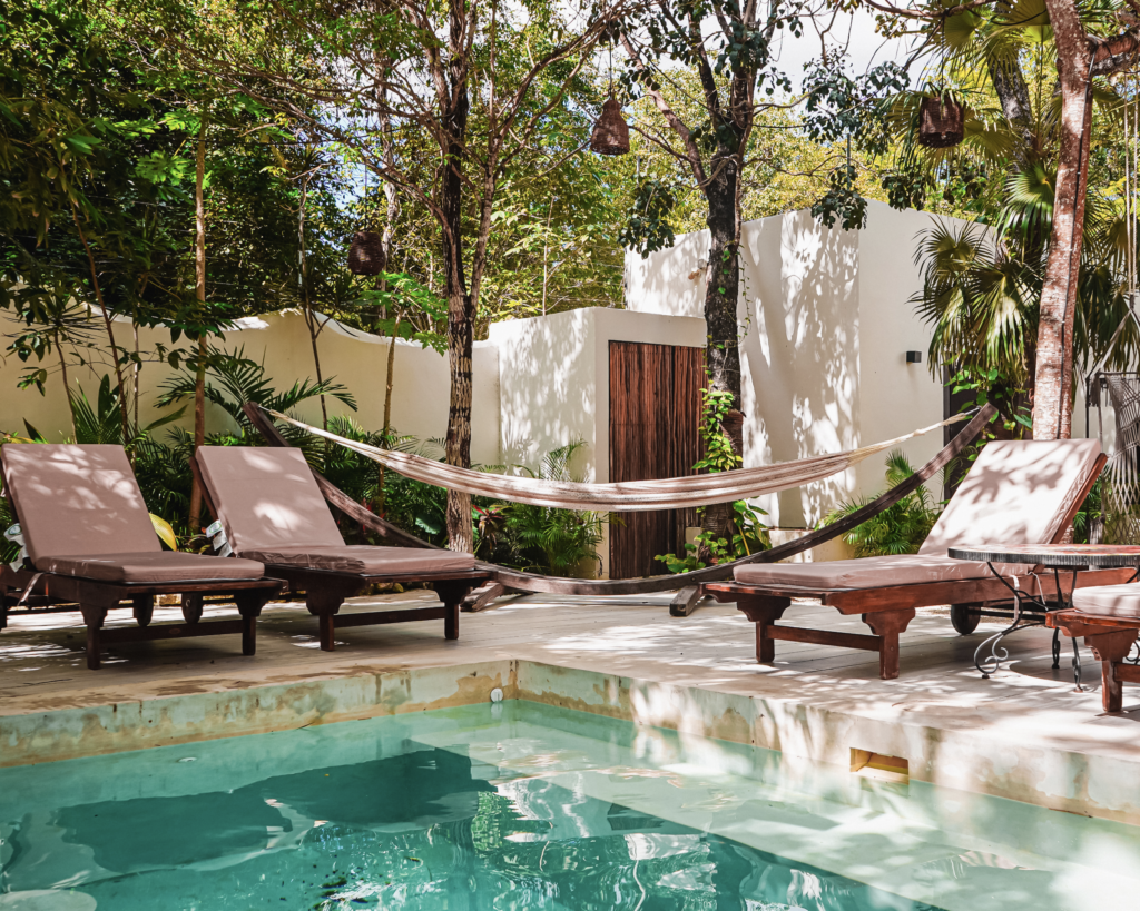 bright-Tulum-pool-with-three-lounge-chairs-and-boho-hammock