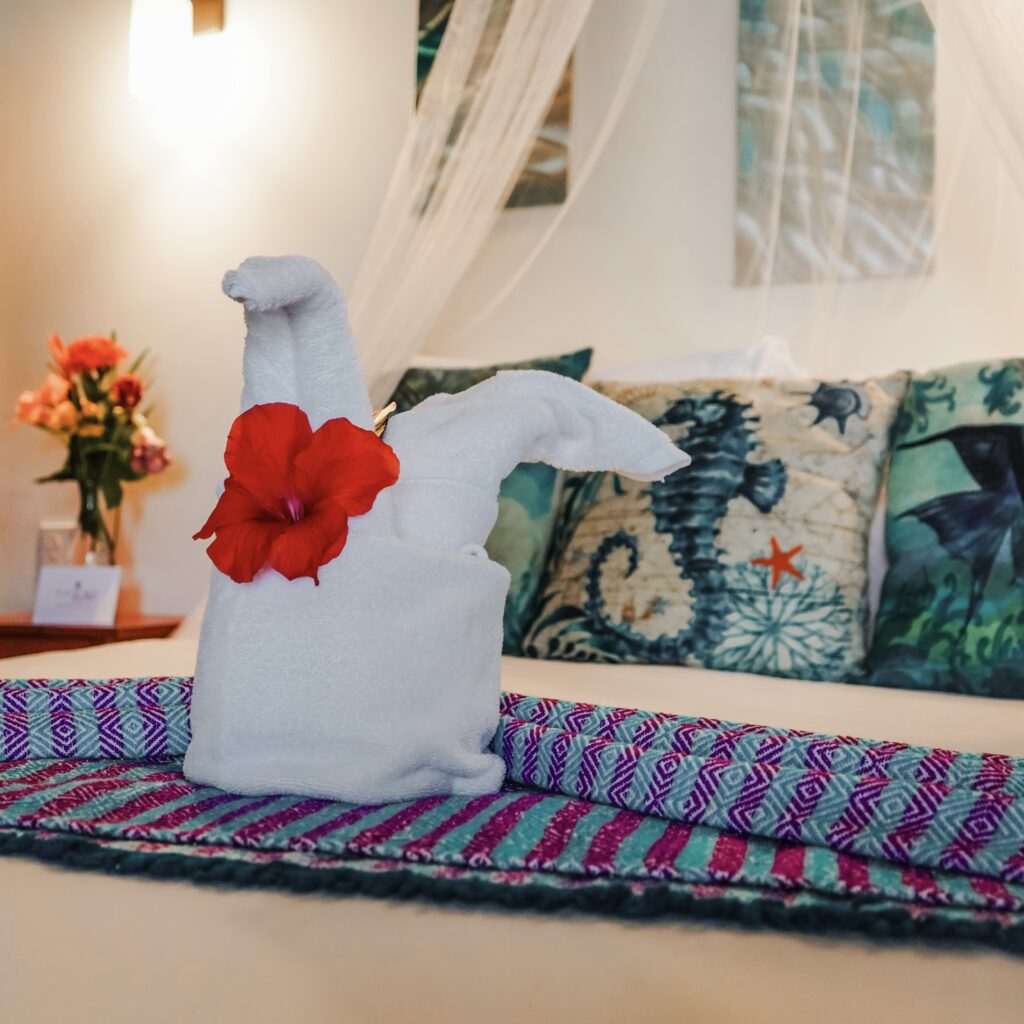 fancy-towel-with-hibiscus-adorning-bed-in-azure-del-mar-cabana