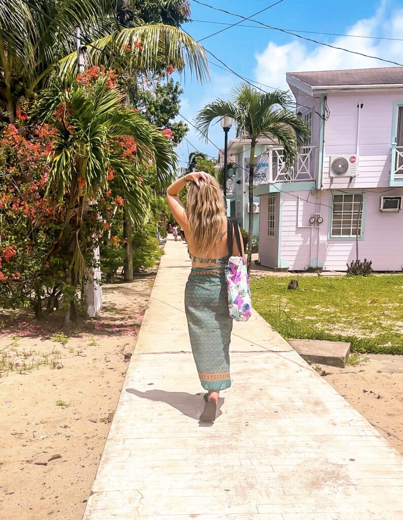 blonde-woman-walking-down-the-sidewalk-narrowest-street-in-the-world-in-placencia-belize