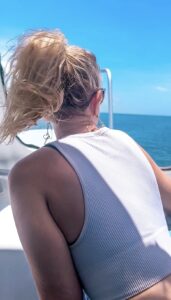 blonde-woman-with-ponytail-and-white-shirt-looking-out-at-caribbean-sea-on-san-pedro-express-water-taxi