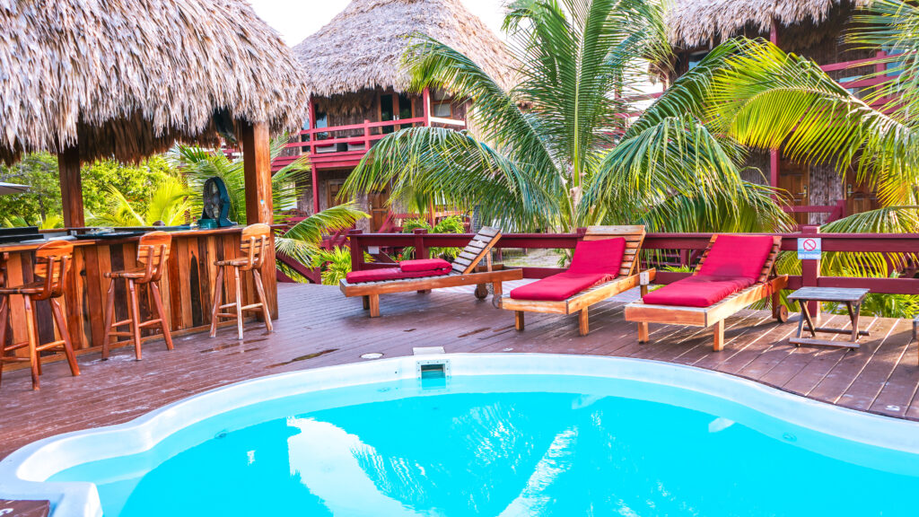 bright-blue-pool-on-deck-with-lounge-chairs-and-bar-at-el-ben-cabanas-belize