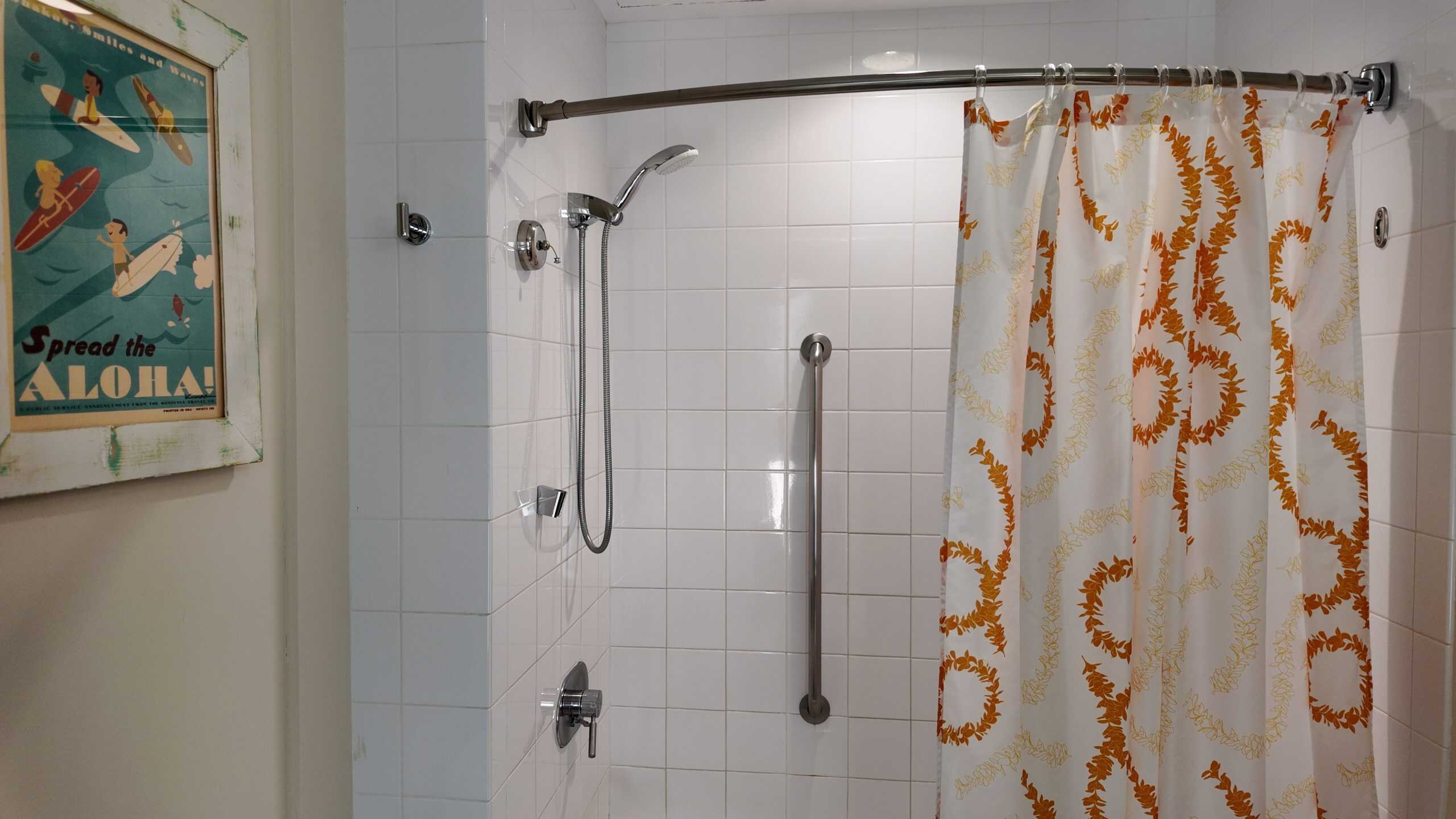 A hotel bathroom with a brightly colored shower curtain.