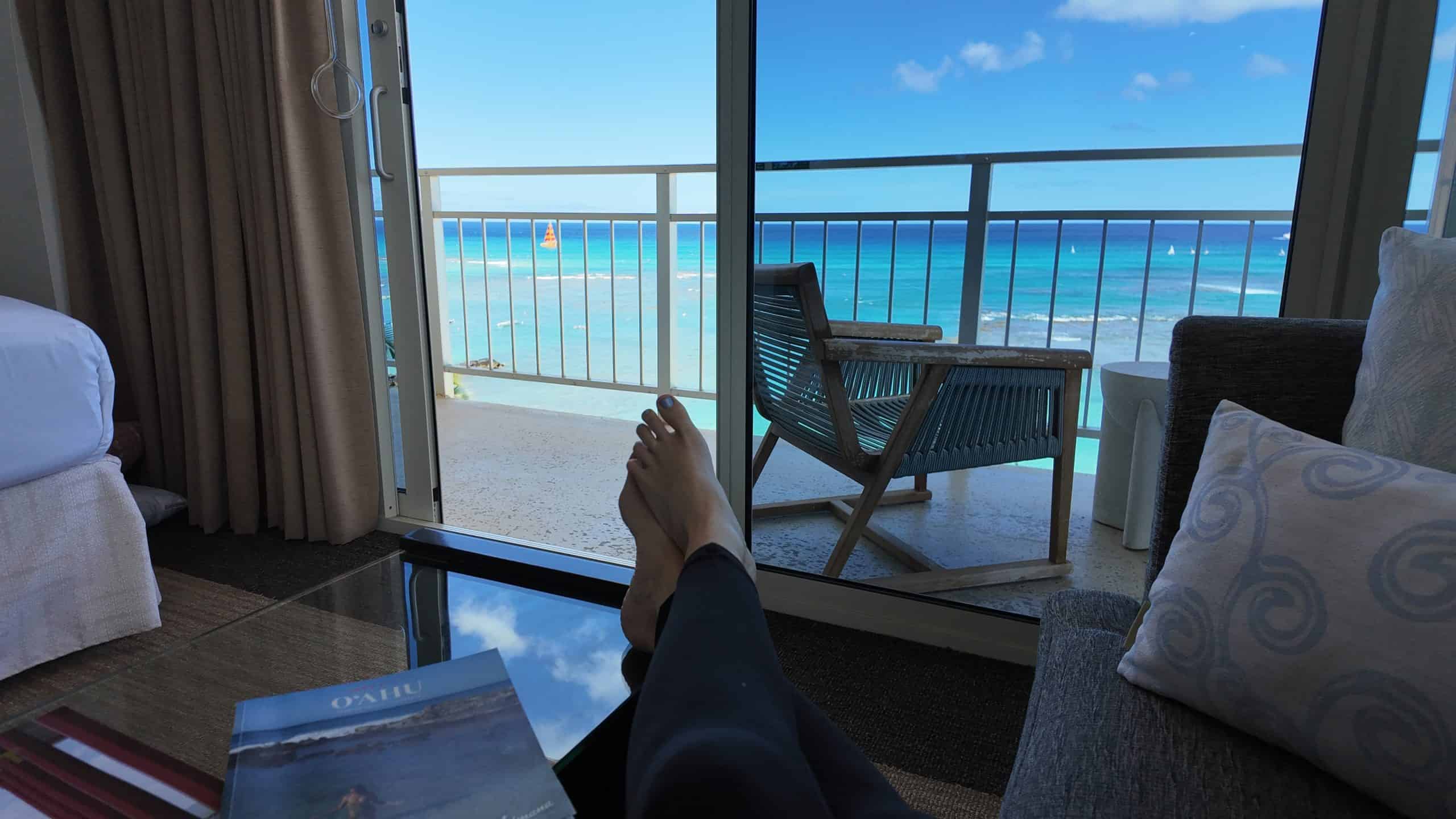 A womans feet lounging and looking out to a tropical ocean