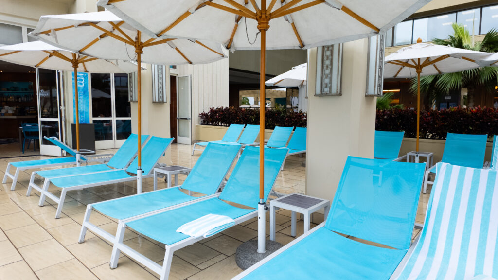 Blue chaise lounge chairs with white umbrellas