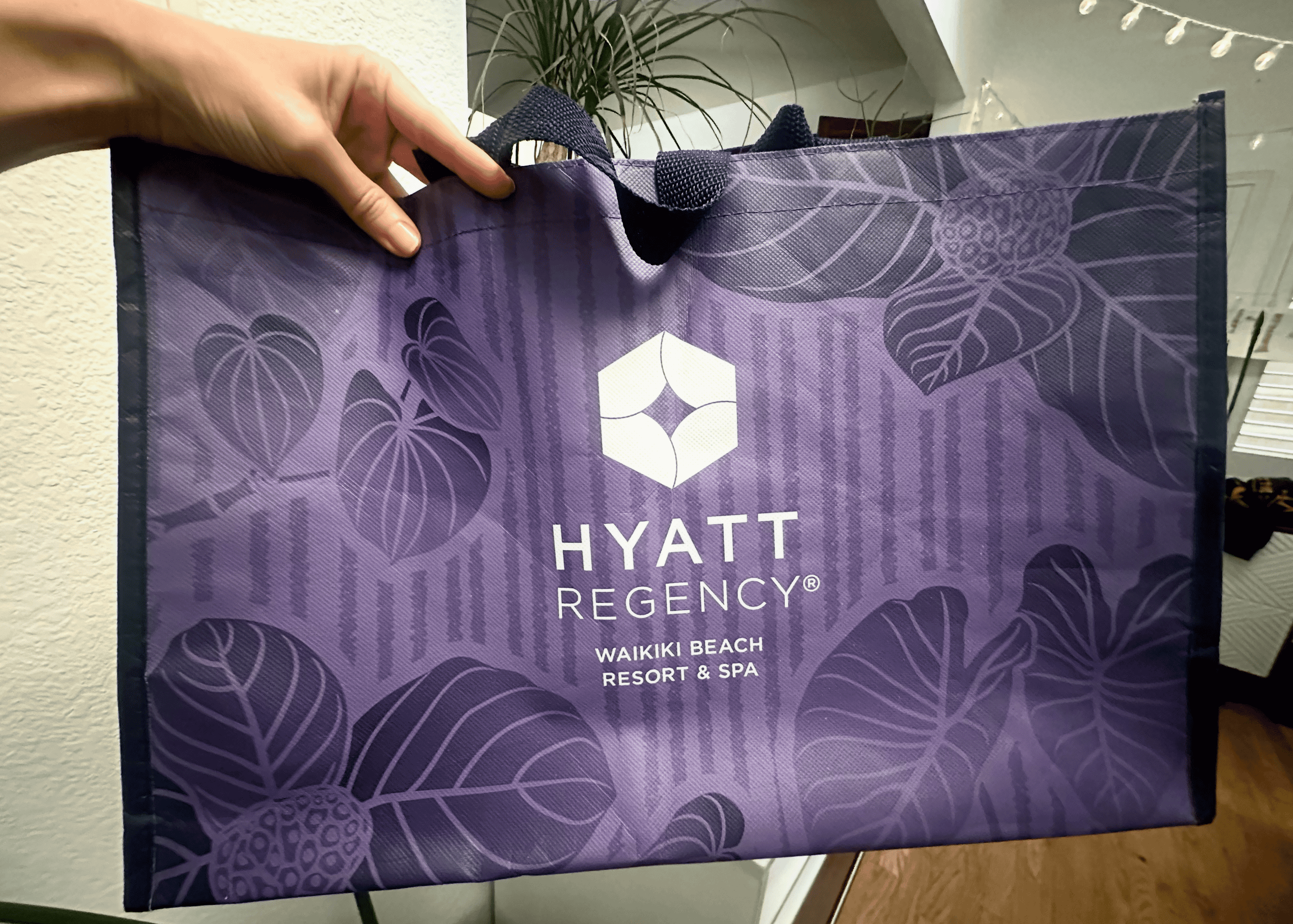 A purple reusable tote bag that says Hyatt Regency Waikiki Beach Resort & Spa