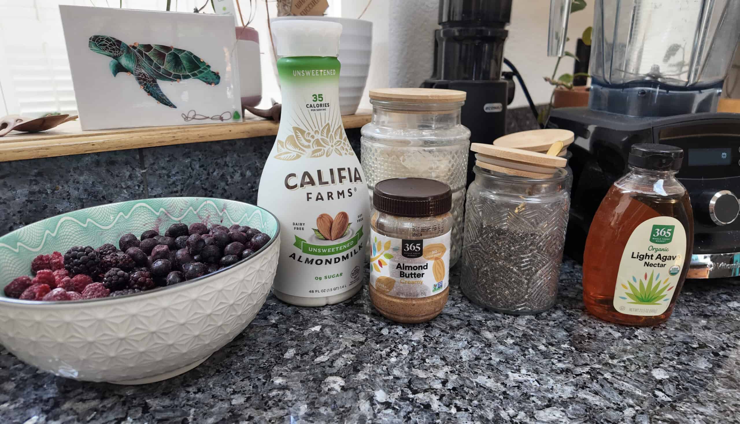 Ingredients including frozen berries, almond milk and almond butter, and various seeds and other dry ingredients.