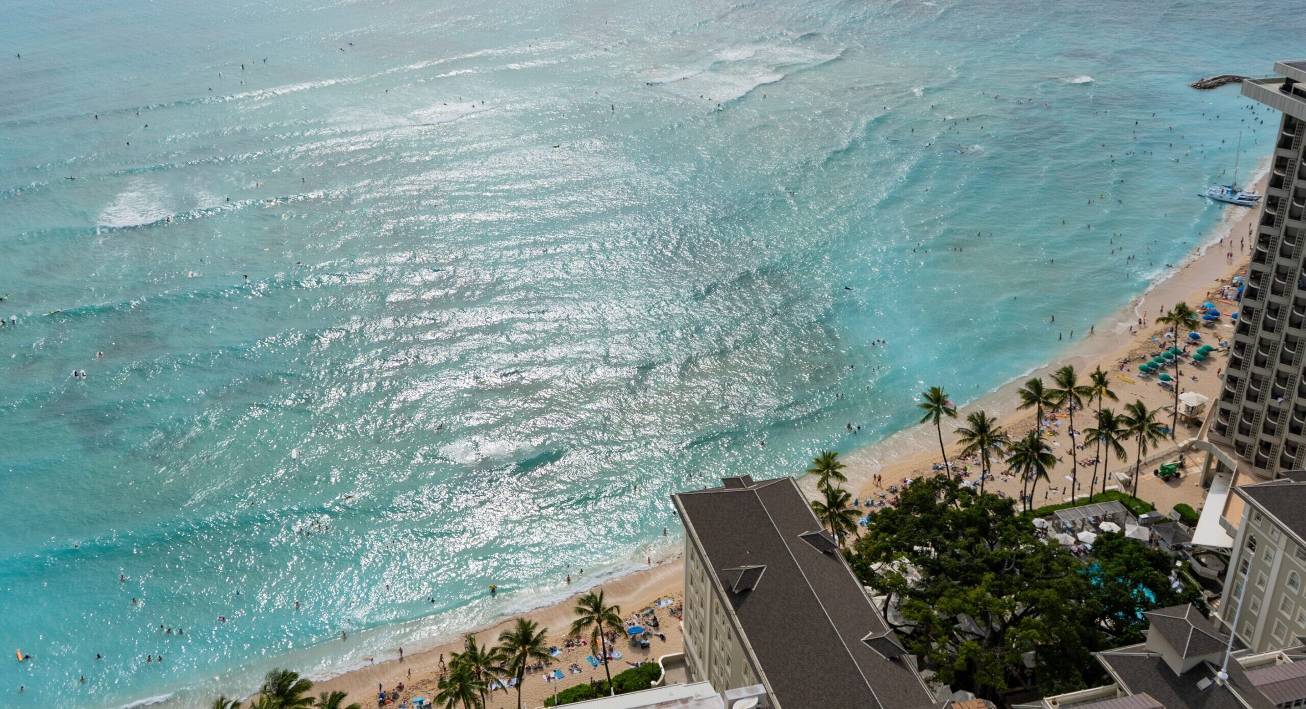 A view shot from a hotel deck in Waikiki, looking out towards the beach and ocean