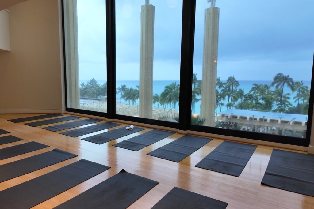 A row of yoga mats in a studio overlooking Waikiki Beach
