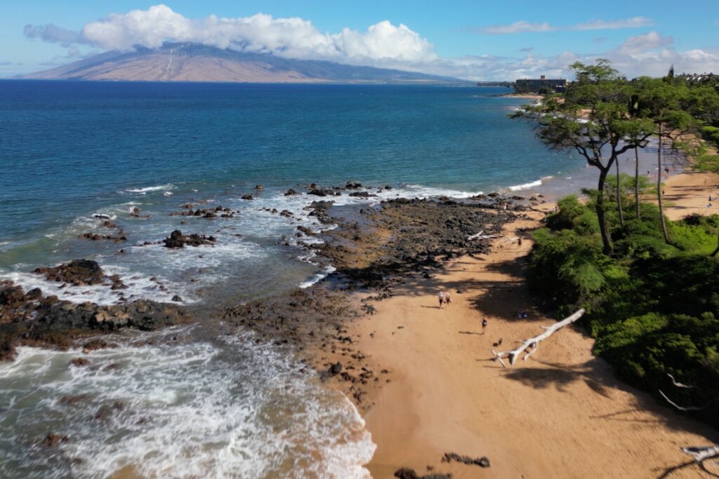 An aerial shot taken over Keawakapu Beach in Maui, looking towards the West Maui Mountains