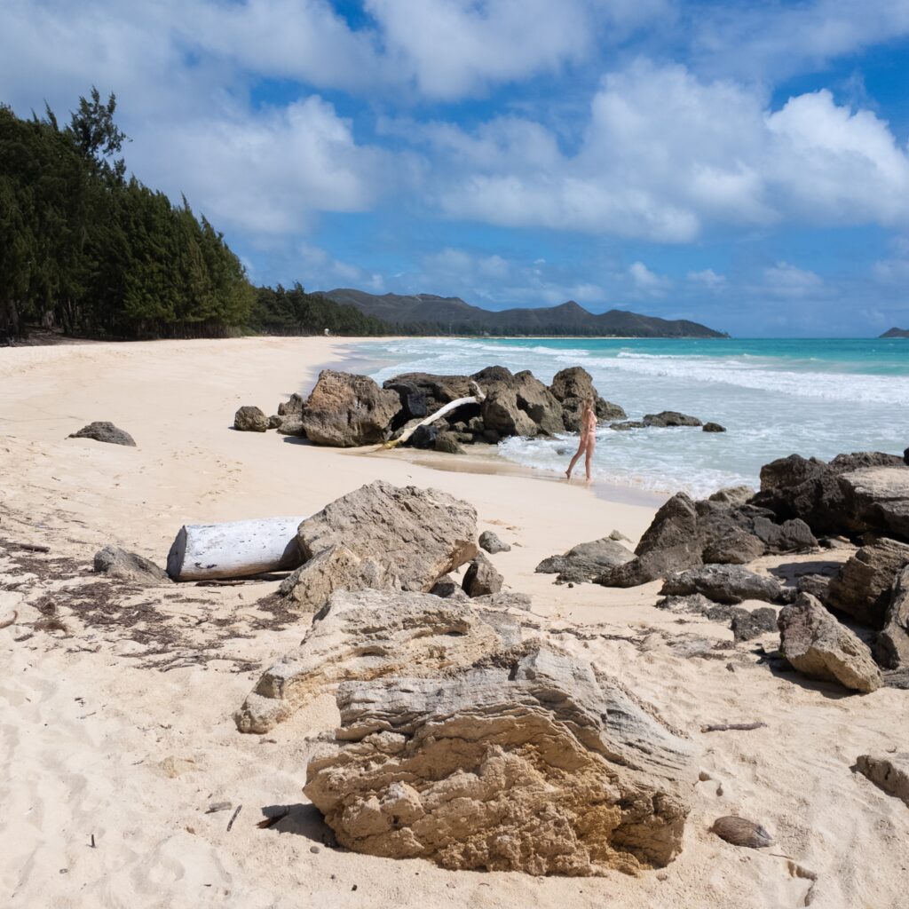 A woman walking towards the ocean at Waimanalo Beach in Oahu