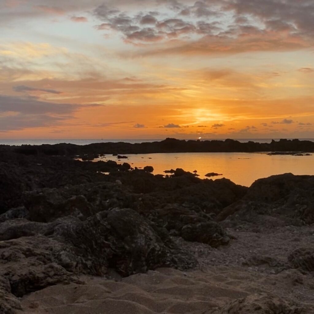 The sun setting over the ocean at Shark's Cove in Haleiwa Oahu