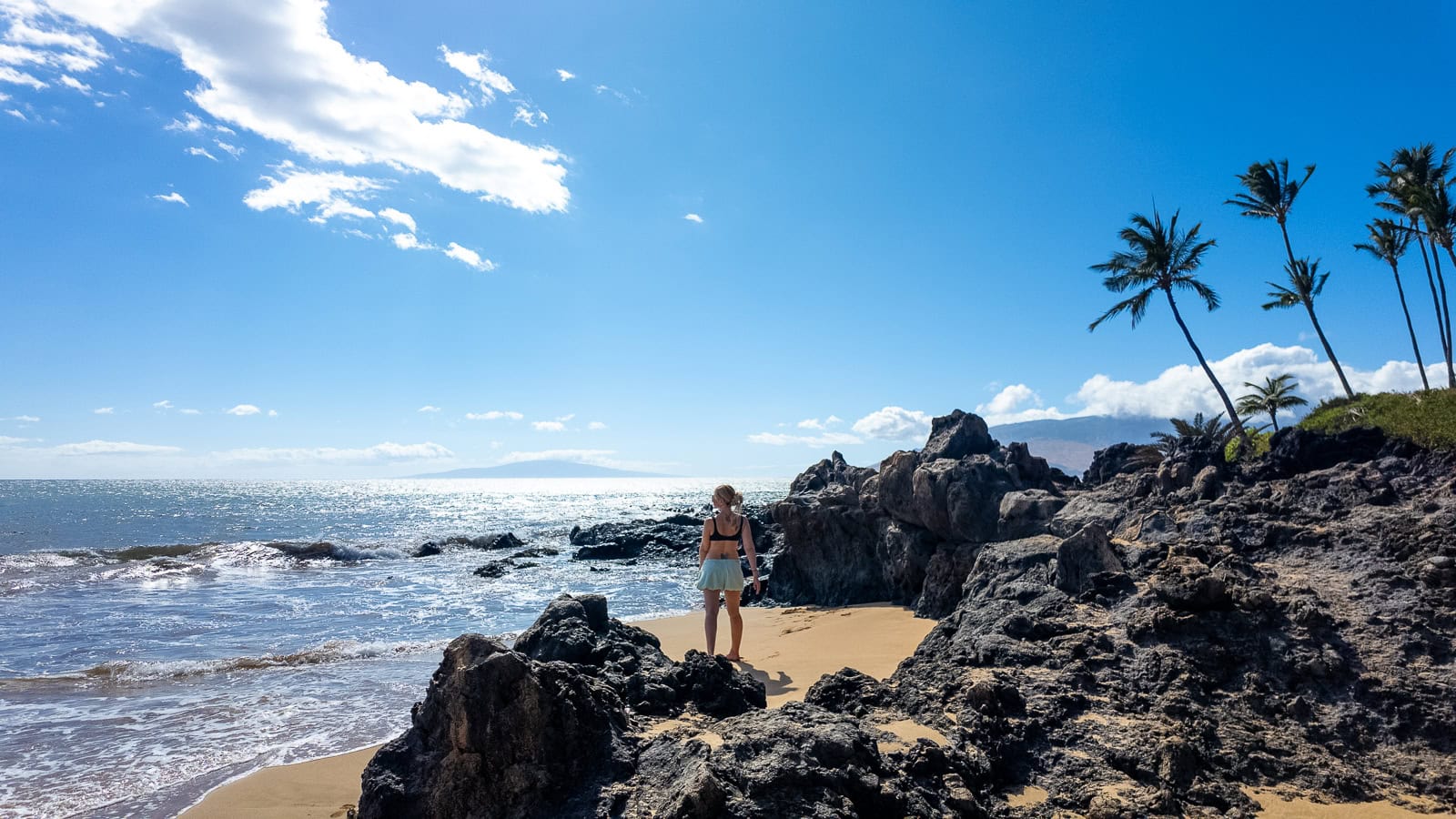 Travel writer Jenny White standing on Kamaole Beach, looking out towards the ocean in Kīhei Maui