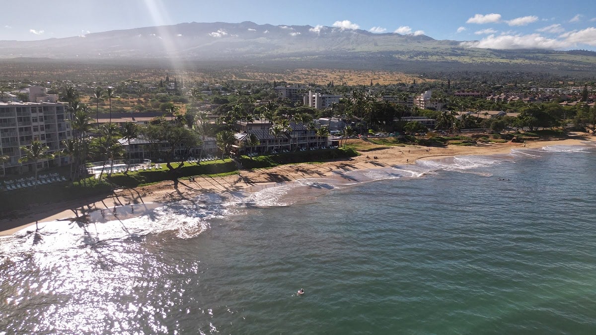 An aerial view of Kamaole Beach Park on a sunny day with Haleakalā in the background